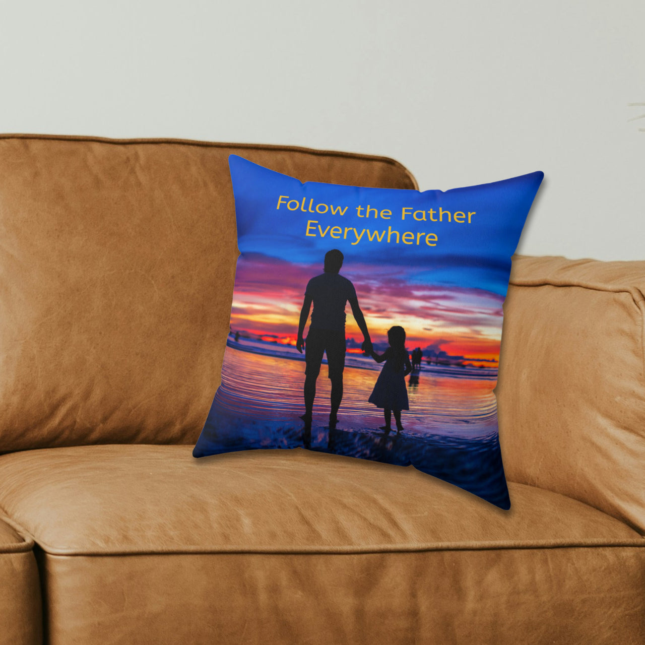 Faith-based throw pillow with “Follow the Father” design, child walking with father, inspirational message "Follow the Father Everywhere, reversible with white or royal blue back, spun polyester, 4 sizes, 14x14 on couch