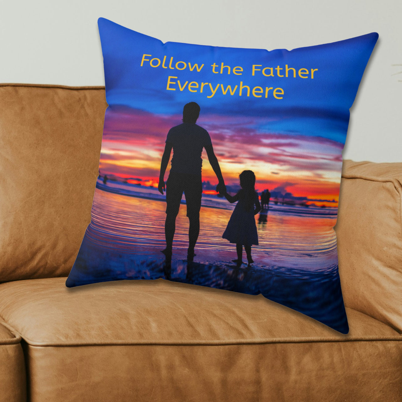 Faith-based throw pillow with “Follow the Father” design, child walking with father, inspirational message "Follow the Father Everywhere, reversible with white or royal blue back, spun polyester, 4 sizes, 20x20 on couch