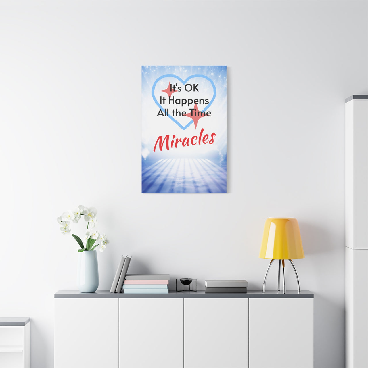Canvas wall art with “Miracles Happen” design with the message "It's Ok, It Happens All the Time - Miracles," pinewood frame, cotton-poly blend, inspirational hope-filled message, ready to hang, 24x36 canvas wall art on wall