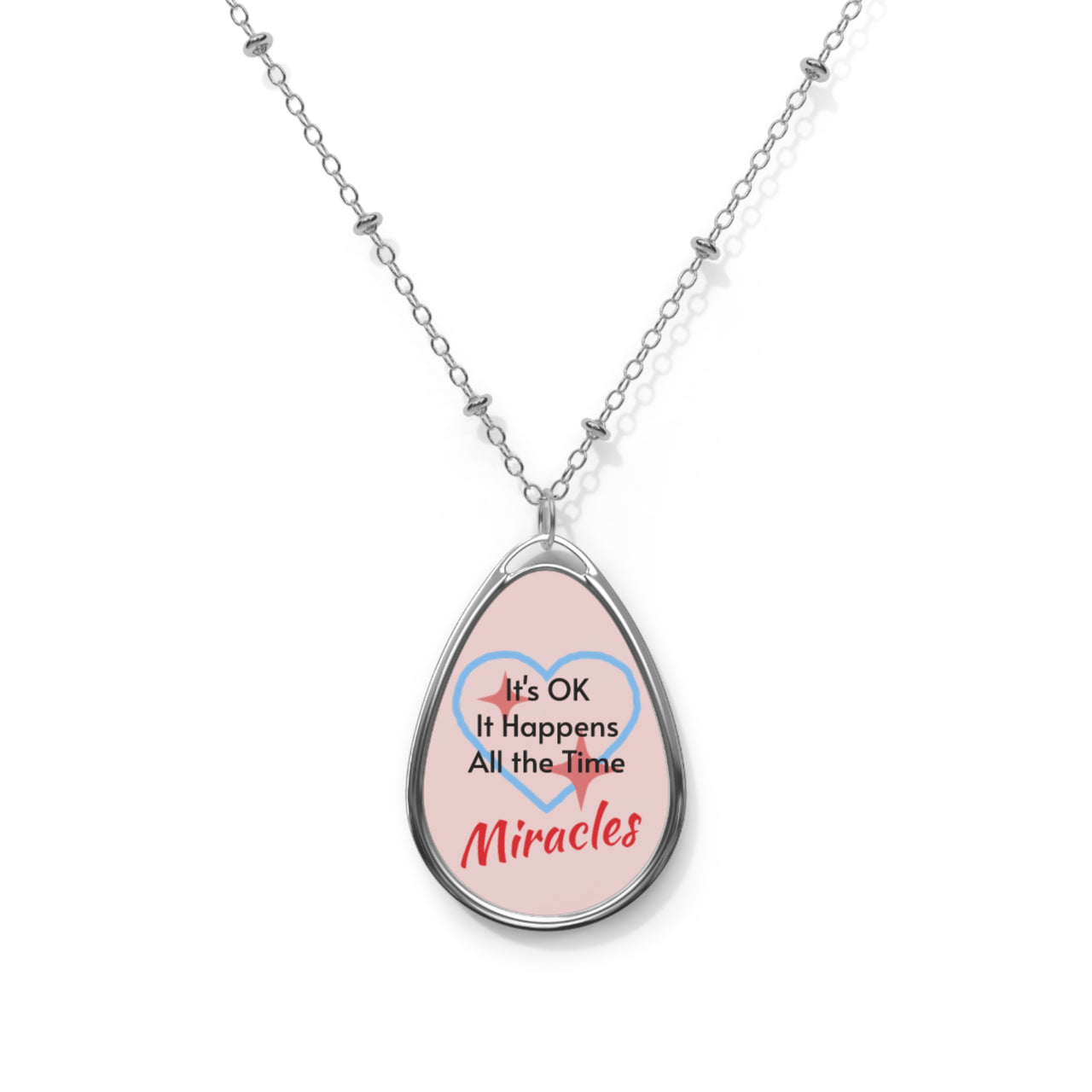 Inspirational oval pendant necklace with "Miracles Happen" design, message “It’s OK. It Happens All the Time – Miracles,” zinc alloy and white aluminum, spiritual jewelry for everyday encouragement, pink pendant