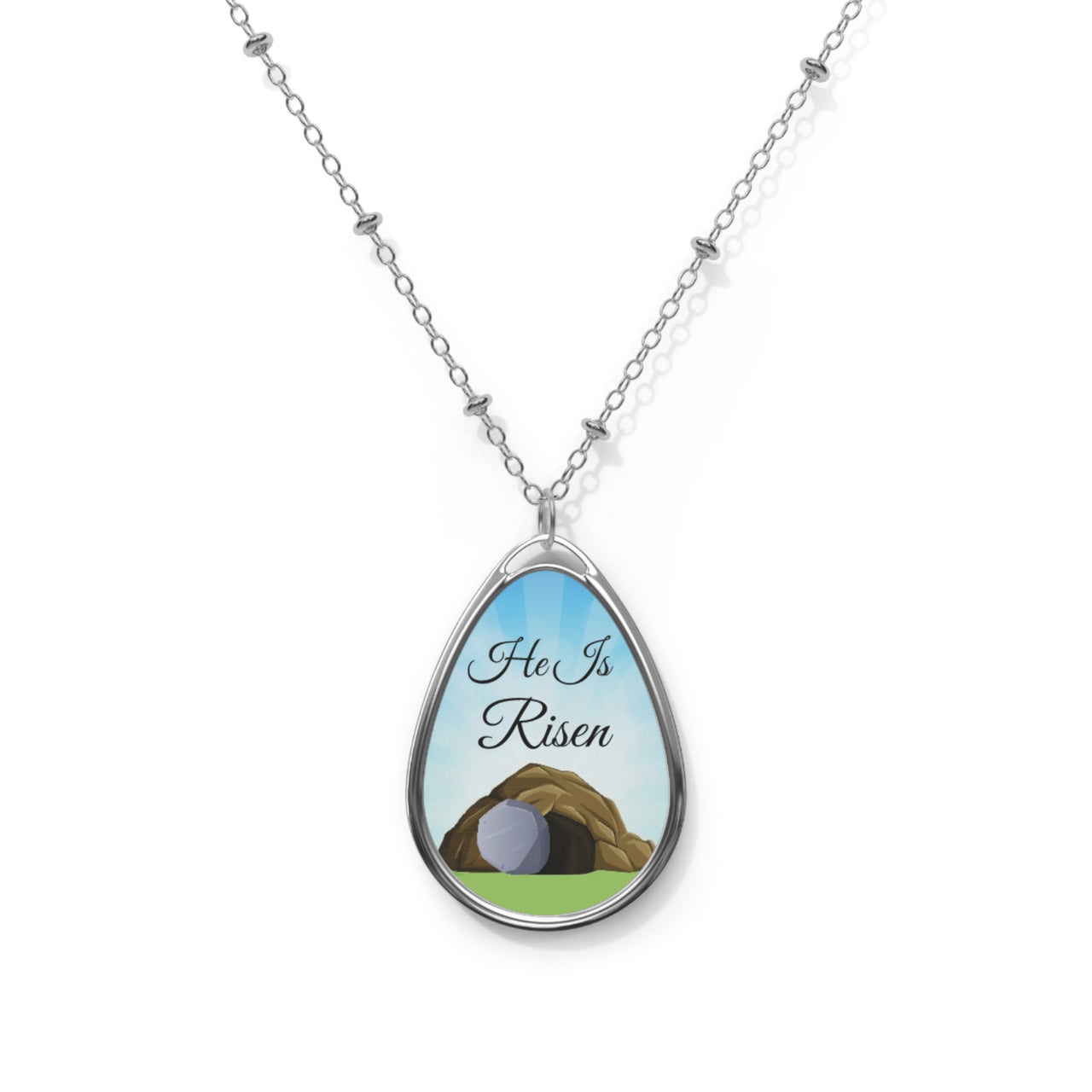 Inspirational oval pendant necklace with "He Is Risen" design,  empty grave artwork, zinc alloy and white aluminum, spiritual jewelry for resurrection faith, front