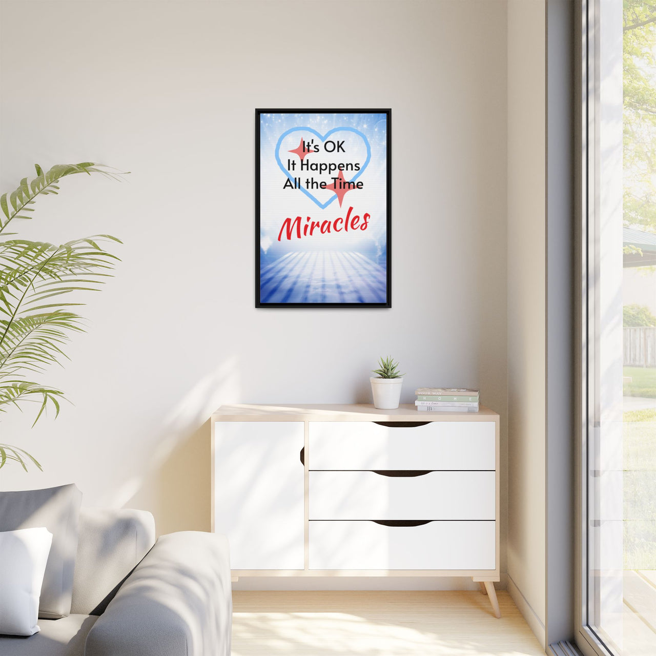 Framed canvas wall art with “Miracles Happen” design, inspirational message "It's OK, It Happens All the Time - Miracles," black pinewood frame, coated cotton-poly canvas, ready to hang, 24x36 framed wall art on wall