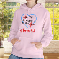 Gildan unisex hoodie with “Miracles Happen” design and uplifting message, Christian apparel made from soft cotton-poly blend, ideal for cooler weather and faith-inspired comfort, woman in pink hoodie