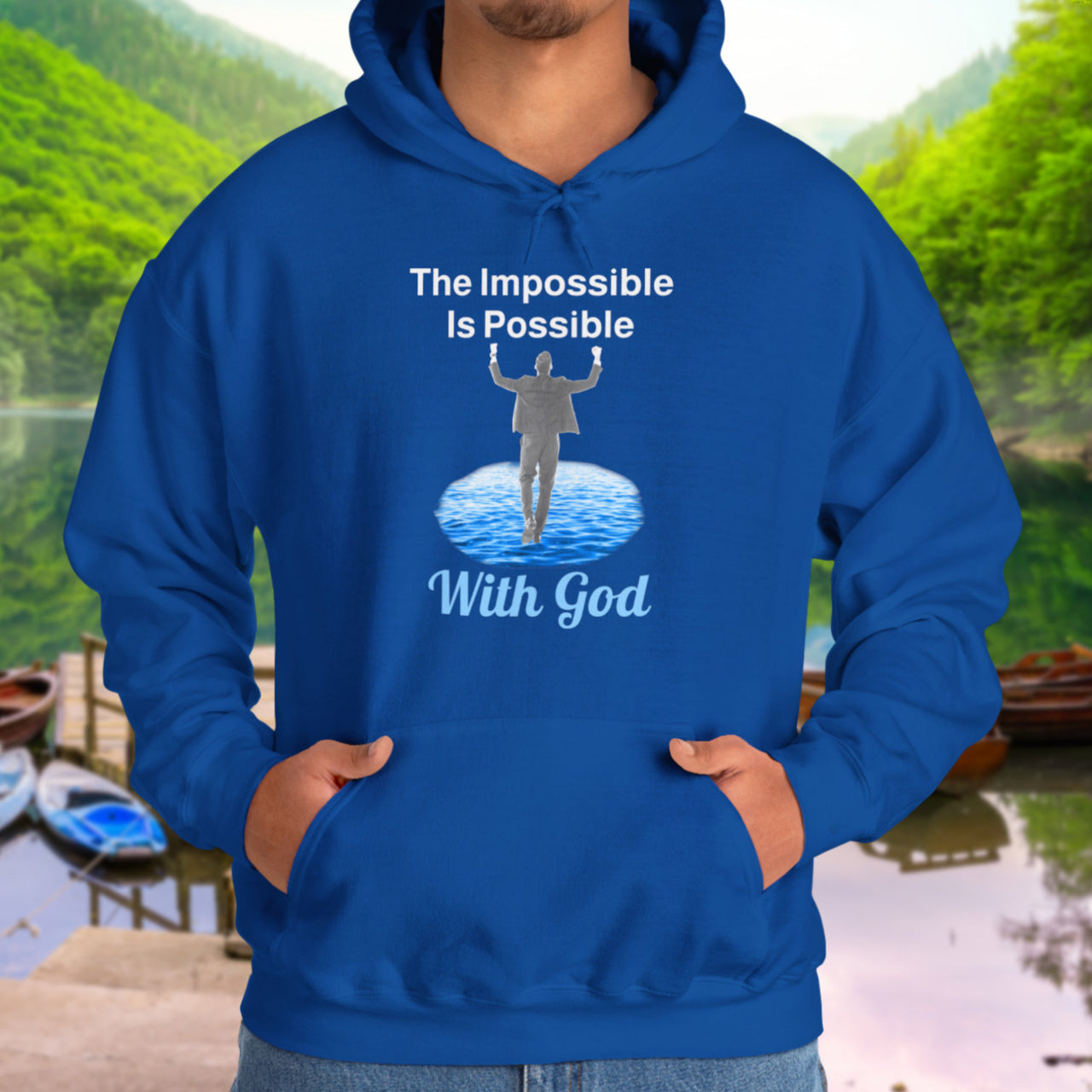 Gildan unisex hoodie with “Impossible Man” design featuring a man walking on water and uplifting message, Christian apparel made from soft cotton-poly blend, perfect for cold weather and spiritual encouragement, man in blue hoodie