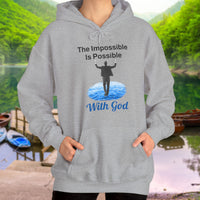 Gildan unisex hoodie with “Impossible Man” design featuring a man walking on water and uplifting message, Christian apparel made from soft cotton-poly blend, perfect for cold weather and spiritual encouragement, woman in gray hoodie