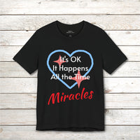 Soft, breathable Bella+Canvas t-shirt made from preshrunk cotton with “Miracles Happen” design message, “It’s OK. It Happens All the Time – Miracles,” inspirational shirt encouraging intimacy with God that produces everyday miracles, front black t-shirt