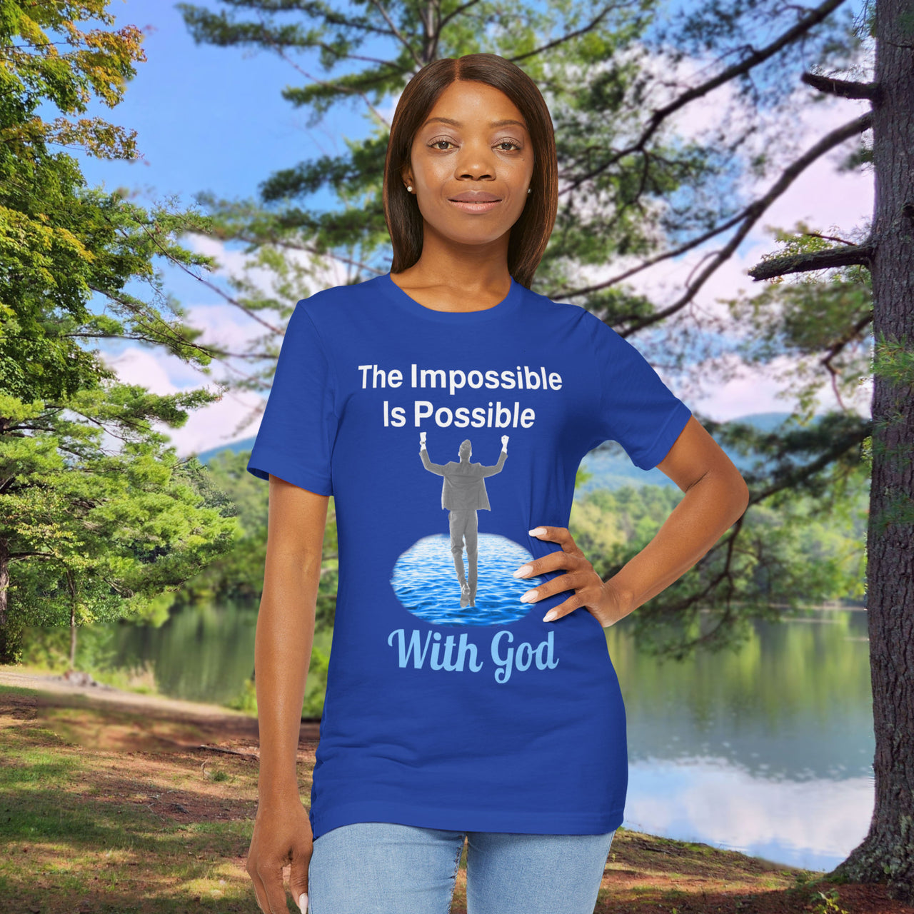Soft, breathable Bella+Canvas t-shirt made from preshrunk cotton with “Impossible Man” design message, “The Impossible Is Possible with God,” inspirational shirt encouraging bold faith to step out and follow God into the impossible, woman in blue t-shirt at park