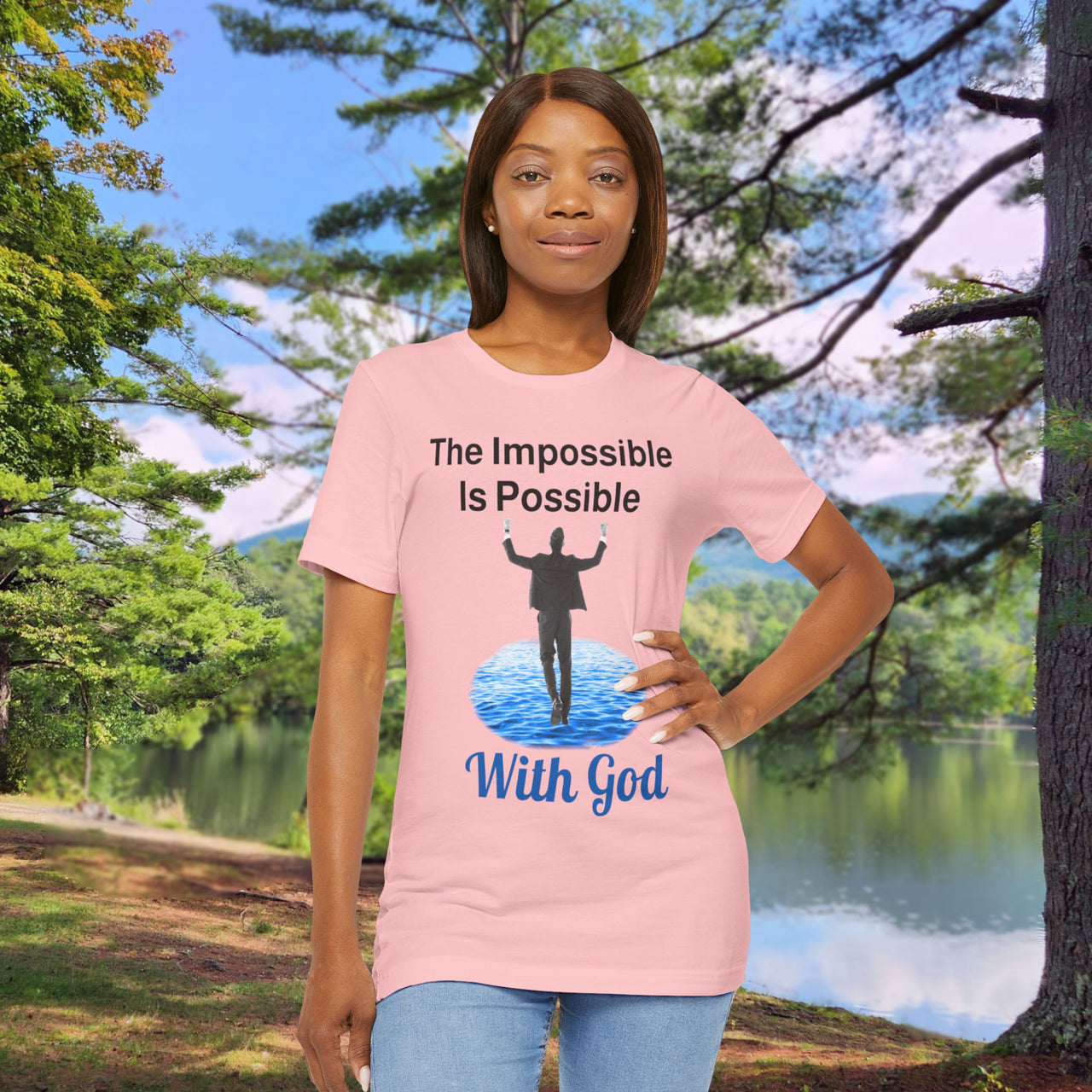 Soft, breathable Bella+Canvas t-shirt made from preshrunk cotton with “Impossible Man” design message, “The Impossible Is Possible with God,” inspirational shirt encouraging bold faith to step out and follow God into the impossible, woman in pink t-shirt at park