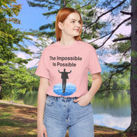 Soft, breathable Bella+Canvas t-shirt made from preshrunk cotton with “Impossible Man” design message, “The Impossible Is Possible with God,” inspirational shirt encouraging bold faith to step out and follow God into the impossible, 2nd woman in pink t-shirt at park