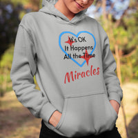 Gildan youth unisex hoodie with “Miracles Happen” design and uplifting message, Christian apparel made from soft preshrunk fleece, ideal for cooler weather and faith-inspired comfort, girl in gray hoodie