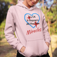 Gildan youth unisex hoodie with “Miracles Happen” design and uplifting message, Christian apparel made from soft preshrunk fleece, ideal for cooler weather and faith-inspired comfort, girl in pink hoodie