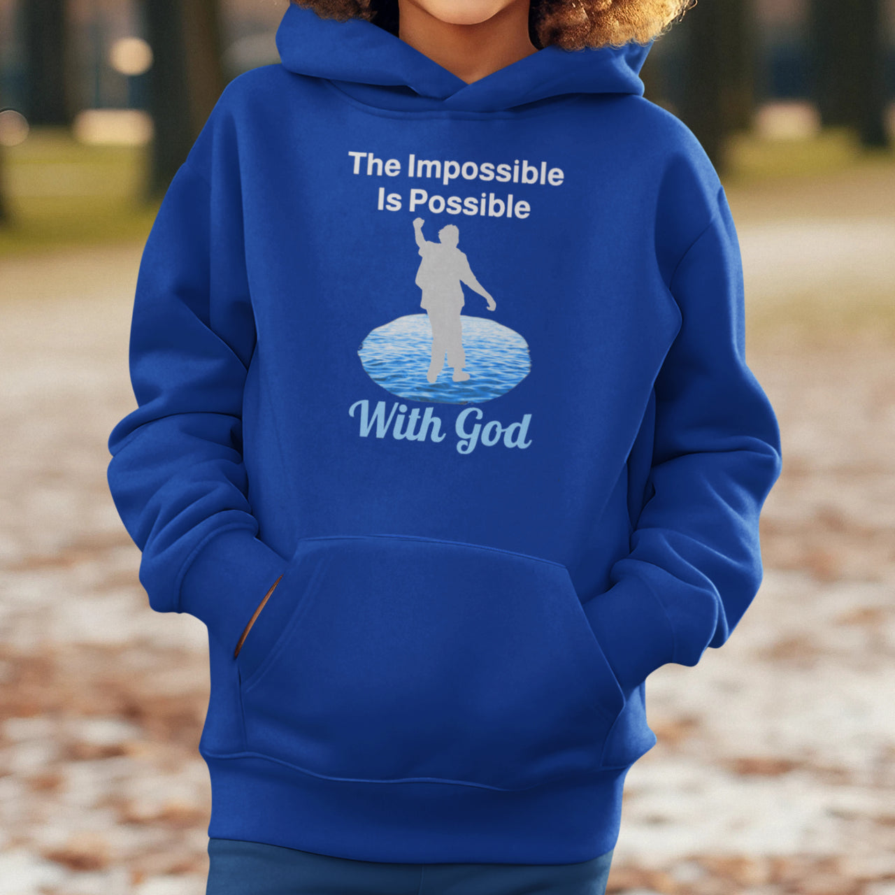 Gildan youth unisex hoodie with “Impossible Teen” design featuring a teen walking on water and uplifting message, Christian apparel made from soft preshrunk fleece, perfect for cold weather and spiritual encouragement, boy in blue hoodie