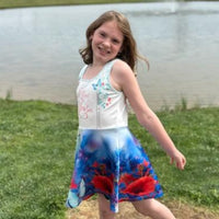 Blue girls’ sundress with butterfly and flower design, “I love you” message, part of Paisley’s Corner Collection, lightweight polyester-spandex blend, ideal for summer and special occasions, girl in butterfly sundress