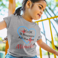 Bella+Canvas toddler t-shirt with “Miracles Happen” design and uplifting message, soft cotton, breathable and durable, Christian apparel for everyday wear and family matching, toddler girl in gray t-shirt