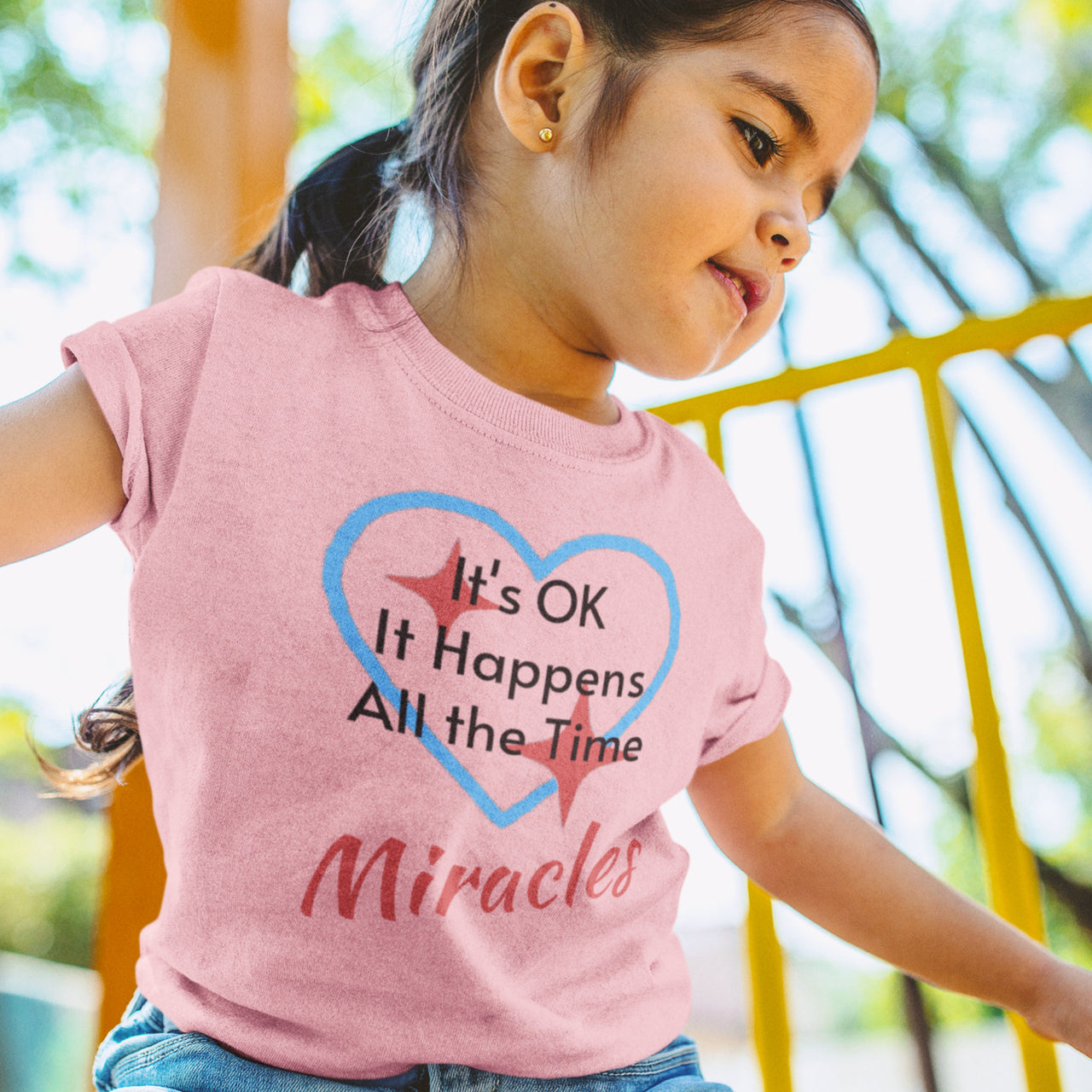 Bella+Canvas toddler t-shirt with “Miracles Happen” design and uplifting message, soft cotton, breathable and durable, Christian apparel for everyday wear and family matching, toddler girl in pink t-shirt