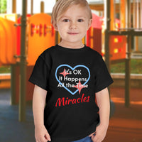 Bella+Canvas toddler t-shirt with “Miracles Happen” design and uplifting message, soft cotton, breathable and durable, Christian apparel for everyday wear and family matching, toddler boy in black t-shirt