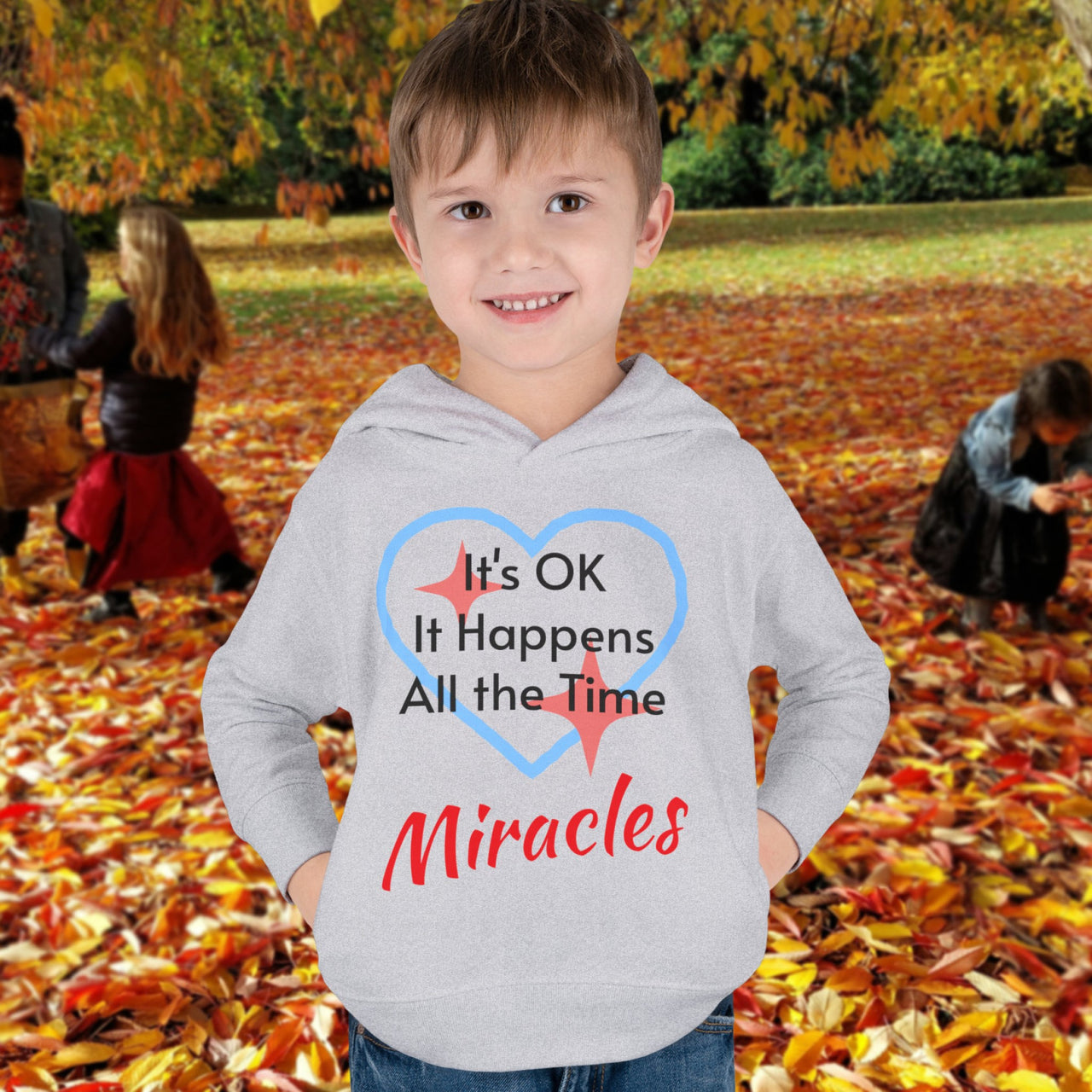 Rabbit Skins toddler fleece hoodie with “Miracles Happen” design and uplifting message, soft cotton-poly blend, jersey-lined hood, Christian apparel for cozy wear and faith-filled gifting, toddler boy in gray hoodie