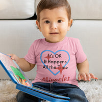 Bella+Canvas baby t-shirt with “Miracles Happen” design and uplifting message, soft cotton, breathable and durable, Christian apparel for infants and family matching, baby boy in pink shirt