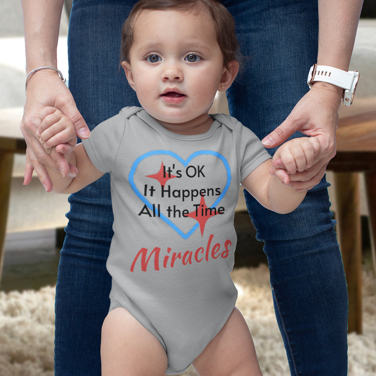 Bella+Canvas baby onesie with “Miracles Happen” design and uplifting message, soft cotton, envelope neck and snap closure, Christian apparel for infants and family matching, baby girl in gray onesie