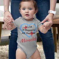 Bella+Canvas baby onesie with “Miracles Happen” design and uplifting message, soft cotton, envelope neck and snap closure, Christian apparel for infants and family matching, baby girl in gray onesie