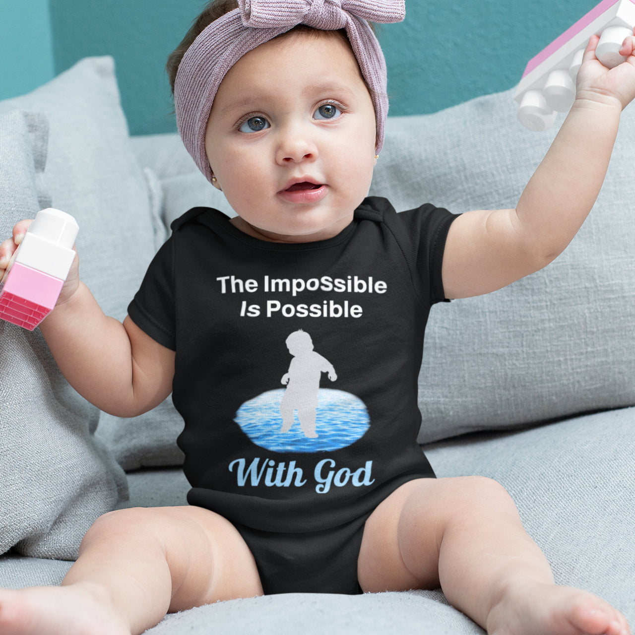 Bella+Canvas baby onesie with “Impossible Baby” design and faith-filled message, soft cotton, envelope neck and snap closure, Christian apparel for infants and spiritual encouragement, baby girl in black onesie