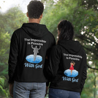 Gildan unisex zip-up hoodie with “Impossible Woman” design featuring a woman walking on water and uplifting message, Christian apparel made from soft cotton-poly fleece, ideal for cooler weather and faith-forward style, couple in black hoodie