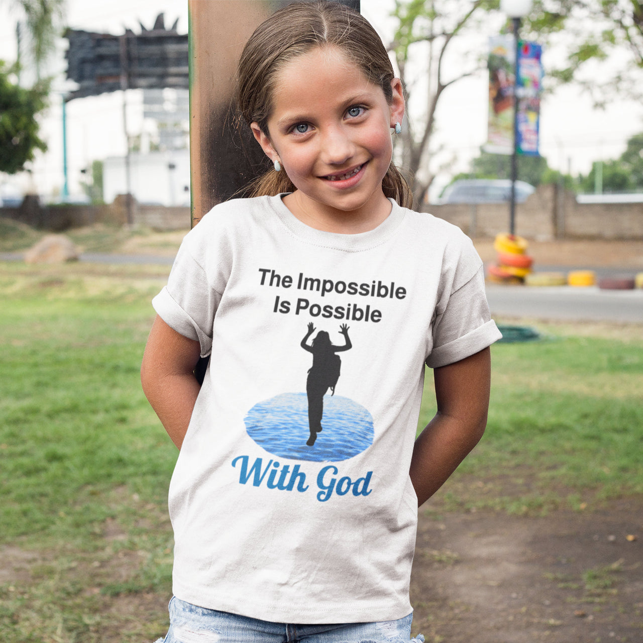 Bella+Canvas youth unisex t-shirt with “Impossible Girl” design featuring a girl walking on water and uplifting message, Christian apparel made from soft cotton, ideal for active wear and faith-forward style, young girl in white t-shirt