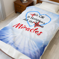 Inspirational plush blanket with “Miracles Happen” design and message 