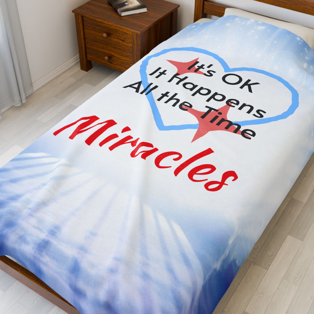 Inspirational plush blanket with “Miracles Happen” design and message "It's OK, It Happens All the Time - Miracles, soft velveteen fabric, faith-based home décor, full print front, white back, throw and twin sizes, twin size on bed