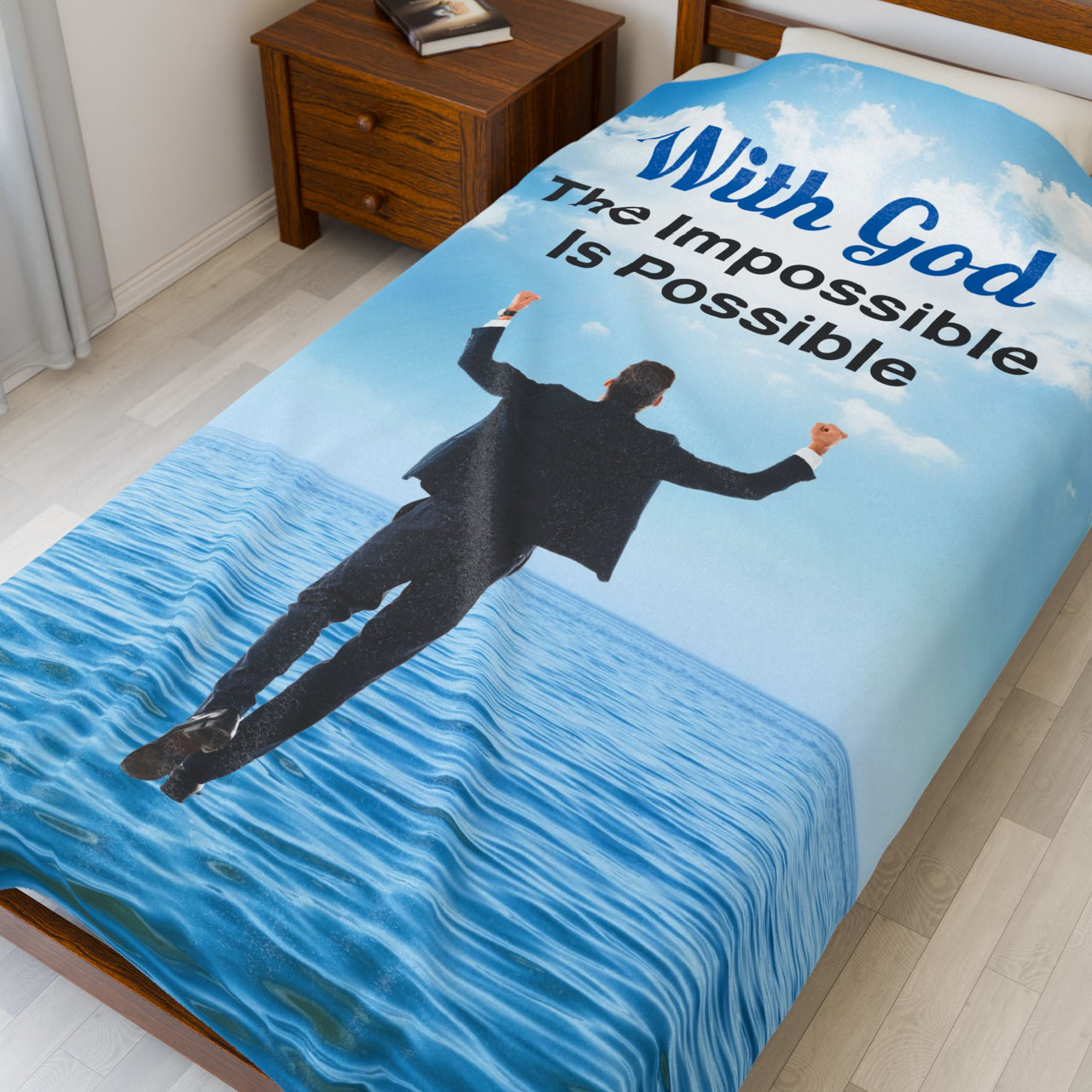 Faith-based plush blanket with “Impossible Man” design, man walking on water,  inspirational message "With God, The Impossible Is Possible," velveteen fabric, full print front, white back, throw and twin sizes, twin size on bed
