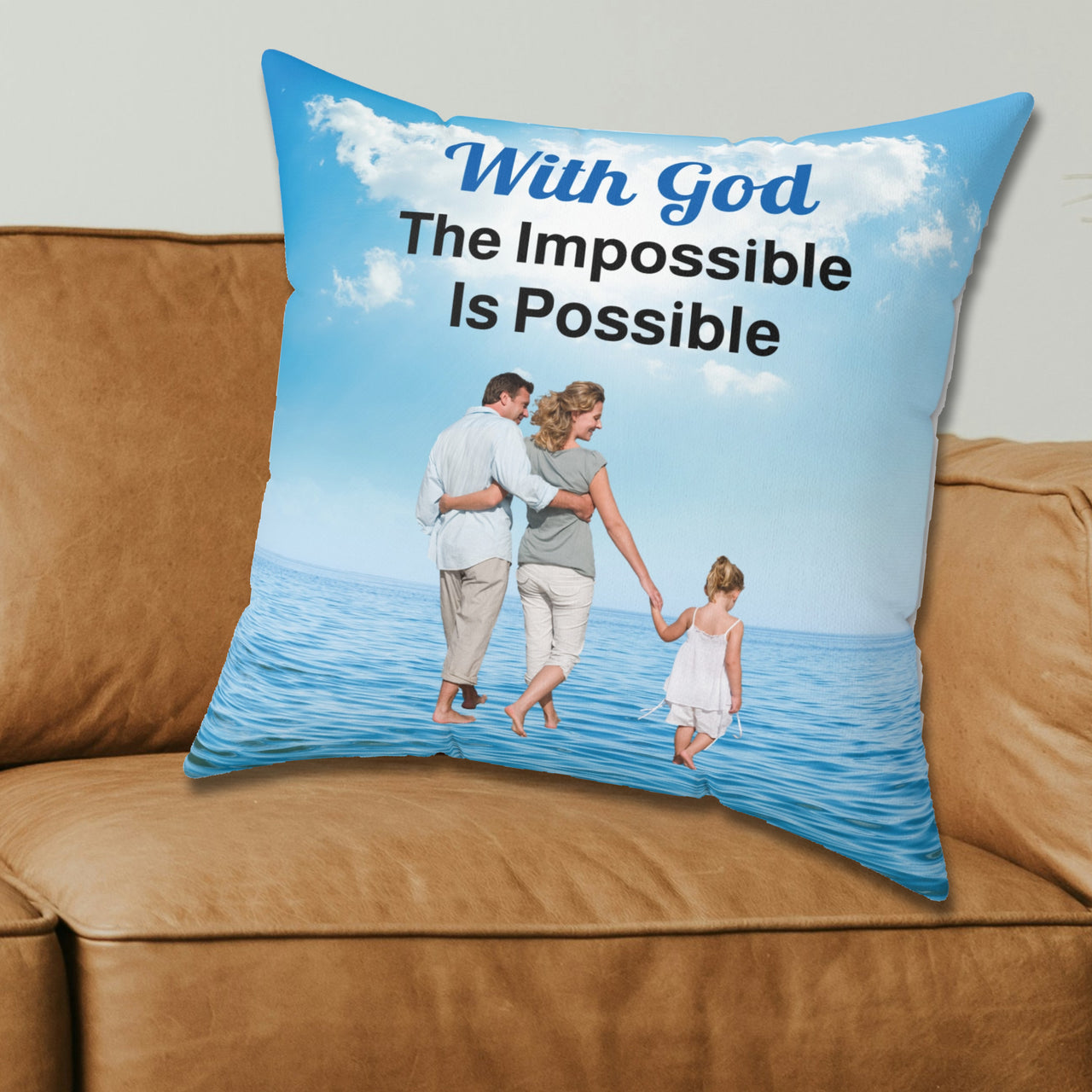 Faith-based throw pillow with “Impossible Family” design, family walking on water with message "With God, The Impossible Is Possible," inspirational home décor, reversible with white or sea blue back, spun polyester, 4 sizes, 20x20 on couch