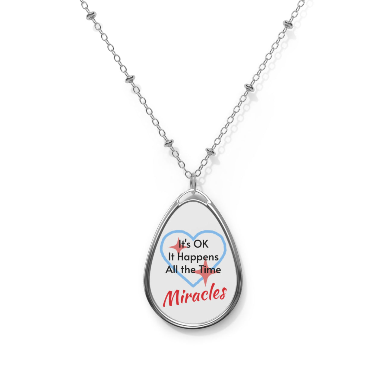Inspirational oval pendant necklace with "Miracles Happen" design, message “It’s OK. It Happens All the Time – Miracles,” zinc alloy and white aluminum, spiritual jewelry for everyday encouragement, front